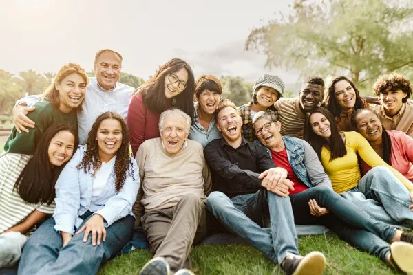 A group of people of different ages smiling together outdoors